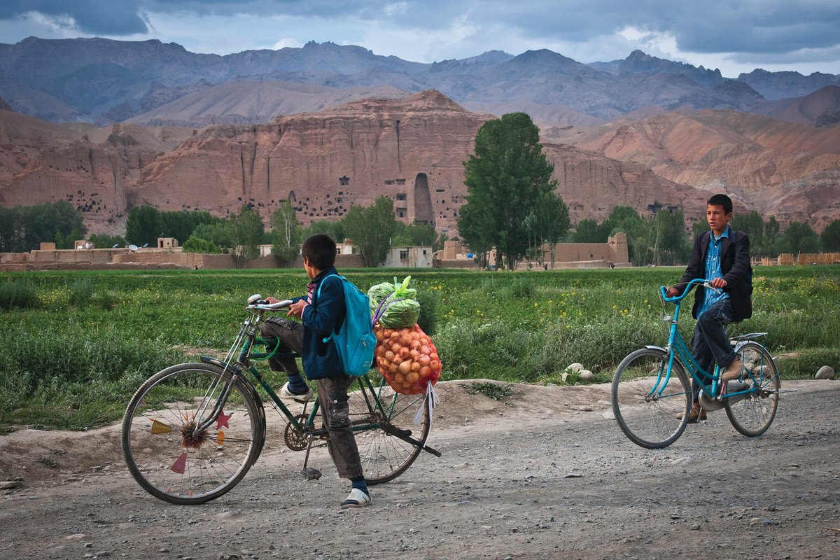 Two boys ride their bicycles past the huge cavity where one of the ancient Buddhas of Bamiyan used to stand. The monumental statues were destroyed by the Taliban in 2001, but the new funding promise brings hope that sites in the Bamiyan valley could be restored
Photo: US Army/Sgt Ken Scar