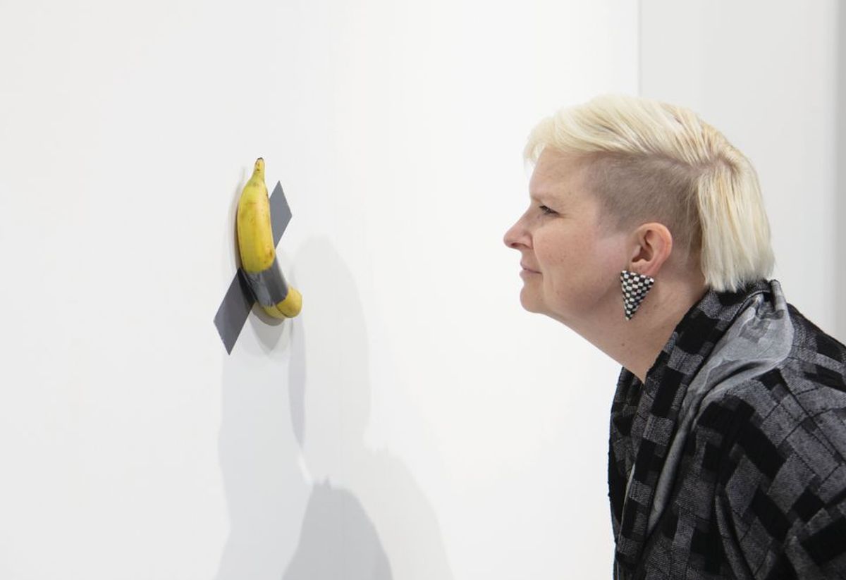 A fair visitor inspects Maurizio Cattelan's new sculpture, Comedian, on Perrotin's stand at Art Basel in Miami Beach in December © David Owens