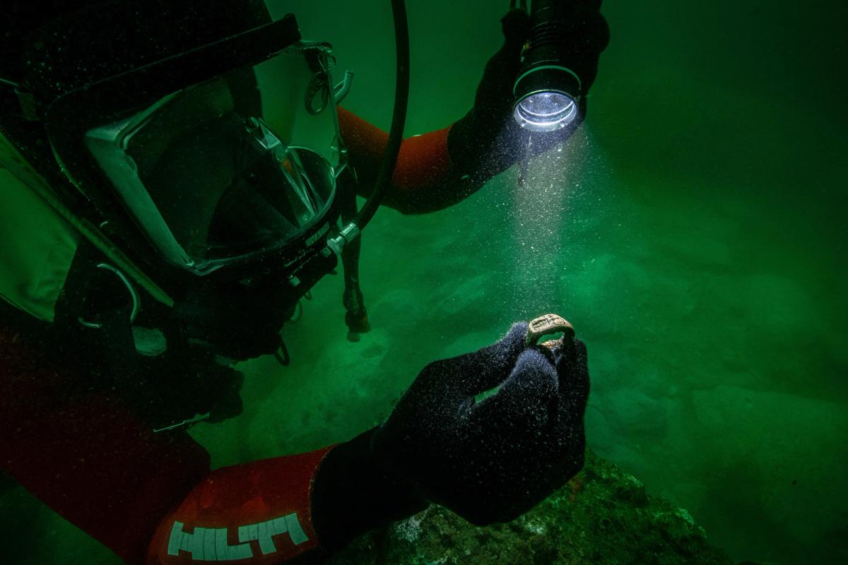 A member of the archaeological team with the submerged ring 

Photo: Christoph Gerigk © Franck Goddio/Hilti Foundation