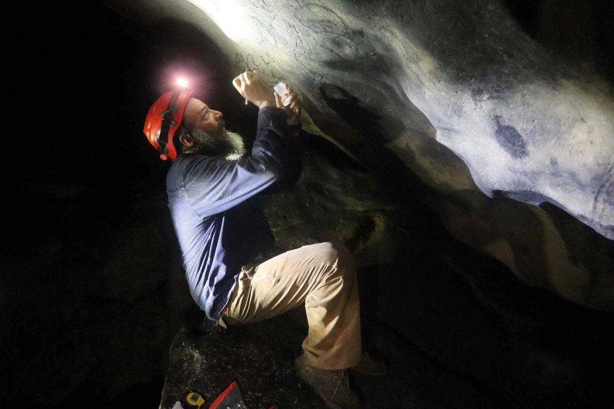 The archaeologist Reniel Rodríguez Ramos examines a pictograph in a cave in Puerto Rico. Some of the drawings have been dated to as early as 740BC
Courtesy Reniel Rodríguez Ramos/University of Puerto Rico at Utuado
