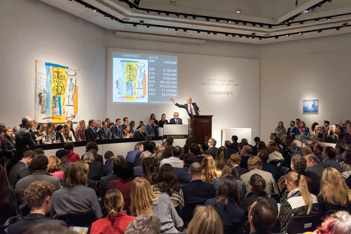 Christie's auctioneer Jussi Pylkkänen sells Jean-Michel Basquiat’s Four Big (1982) Courtesy of Christie's