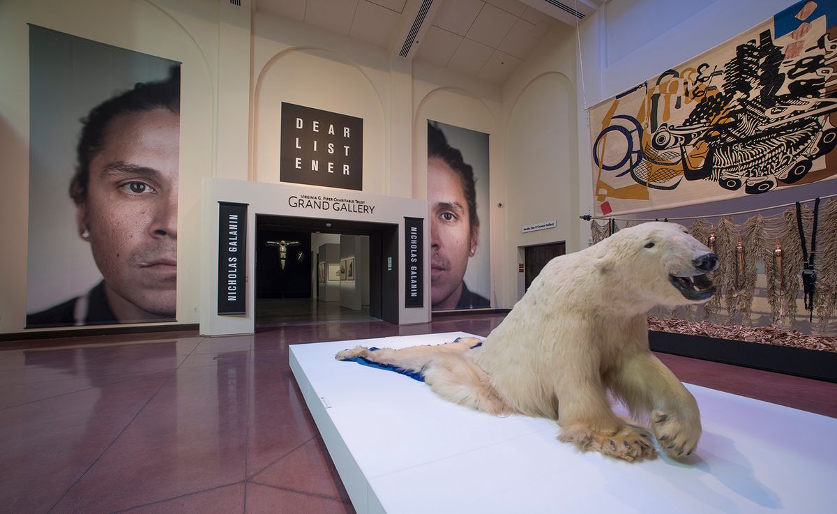 Nicholas Galanin’s mid-career survey at the Heard Museum in Phoenix begins in a spacious gallery, where a photograph of the artist’s head has been blown up and split in half 