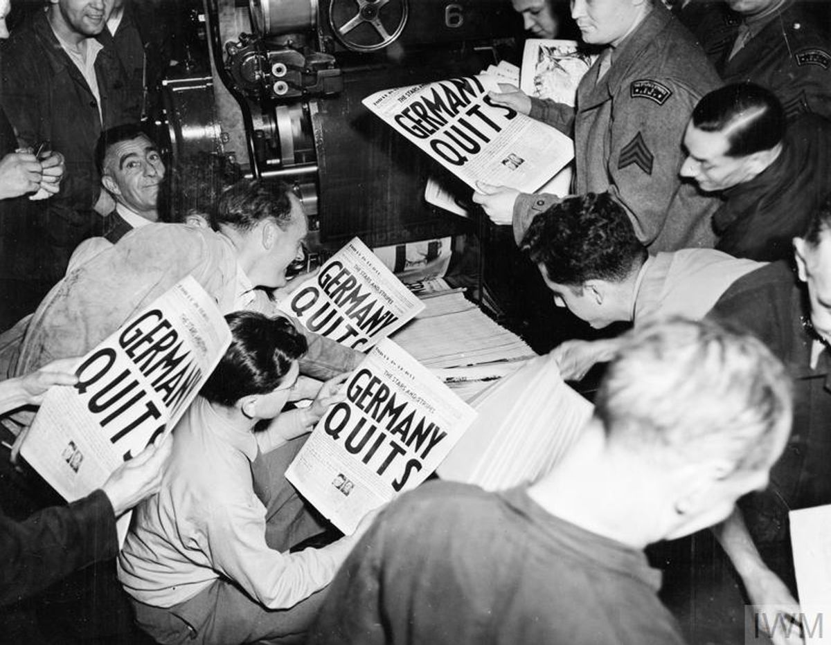 Eager soldiers pulling copies of "Stars and Stripes" from the press of the London Times at 9 pm on 7 May 1945, when an extra edition was put out to announce the news of Germany's surrender © IWM EA 65948