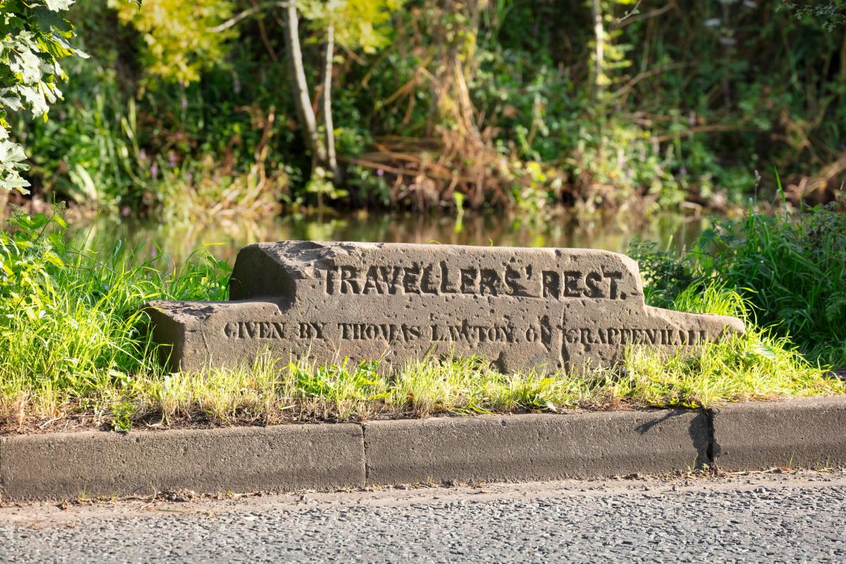 A Travellers' Rest stone in the south verge to Chester Road and adjacent to the Bridgewater Canal, opposite Barrymore Road, Grappenhall, Warrington, Cheshire © Historic England Archive