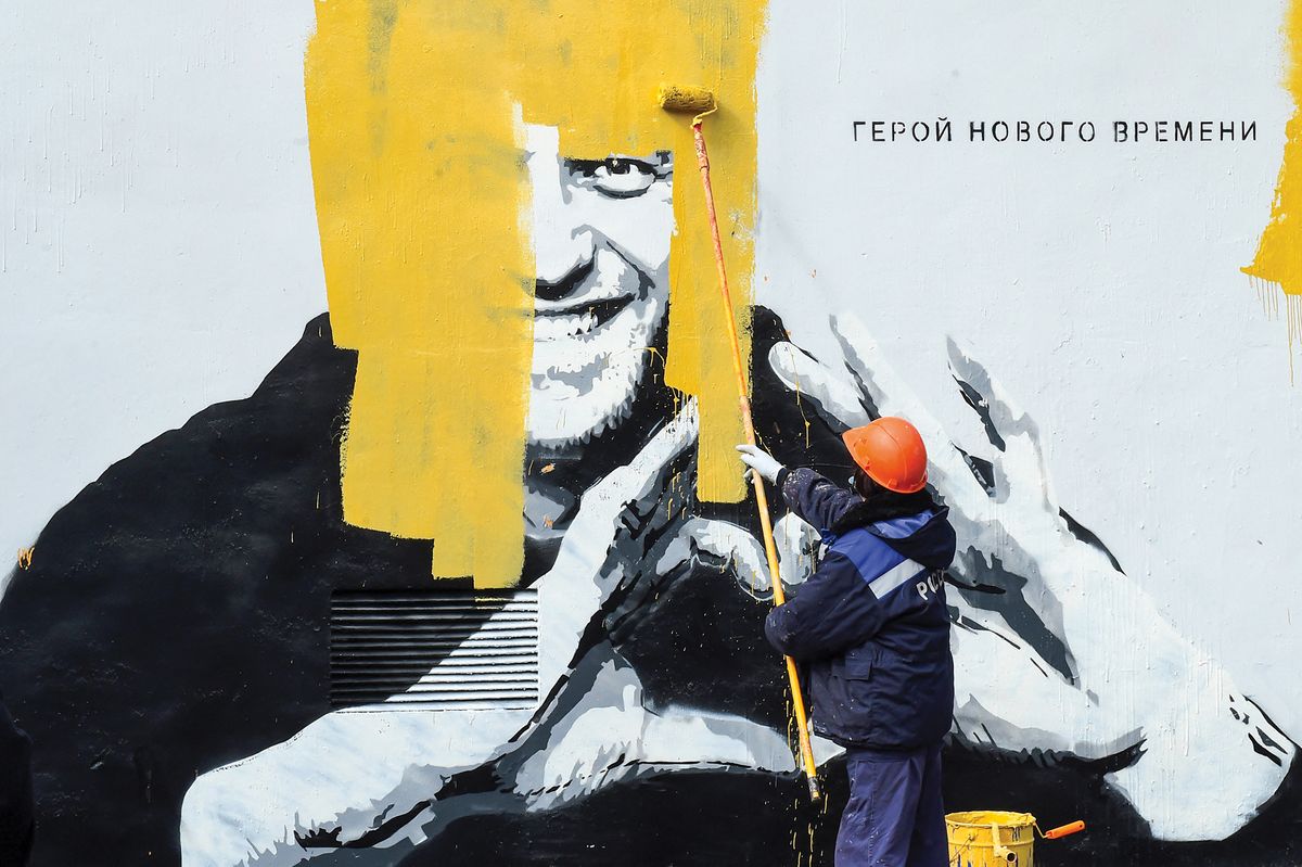 A worker in St Petersburg paints over graffiti depicting Alexei Navalny, who died in prison last month. The Russian opposition leader was jailed in 2021; in 2020 security services poisoned him with novichok Olga Maltseva/AFP via Getty Images