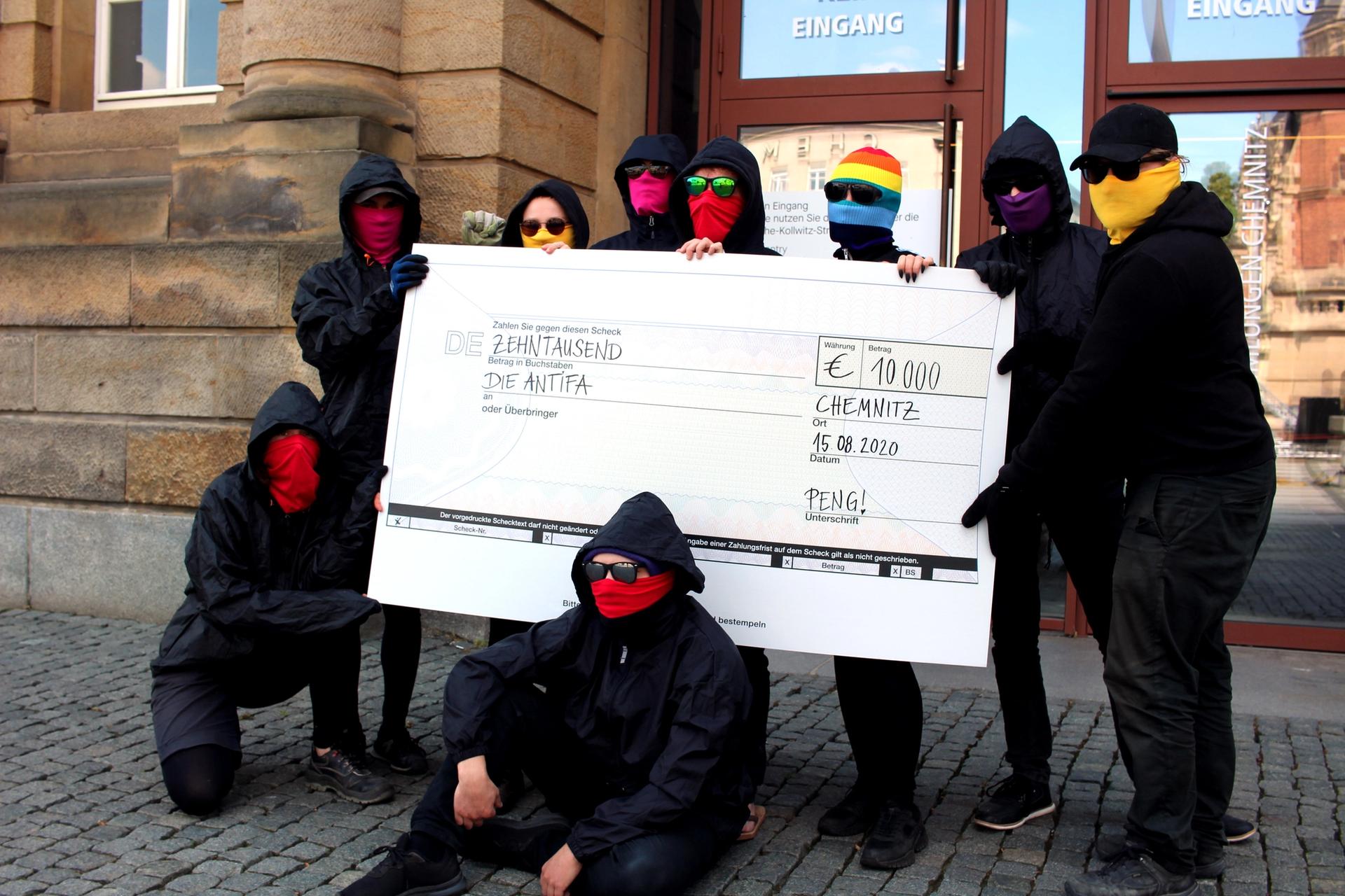 Peng Collective with a €10,000 cheque written out to antifa, an anti-fascist protest movement Photo: Peng Collective