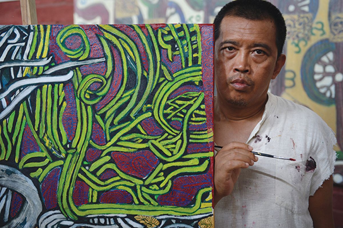 Myanmar artist Htein Lin on 12 November 2015, alongside his painting in his studio in Yangon Photo: ROMEO GACAD/AFP via Getty Images