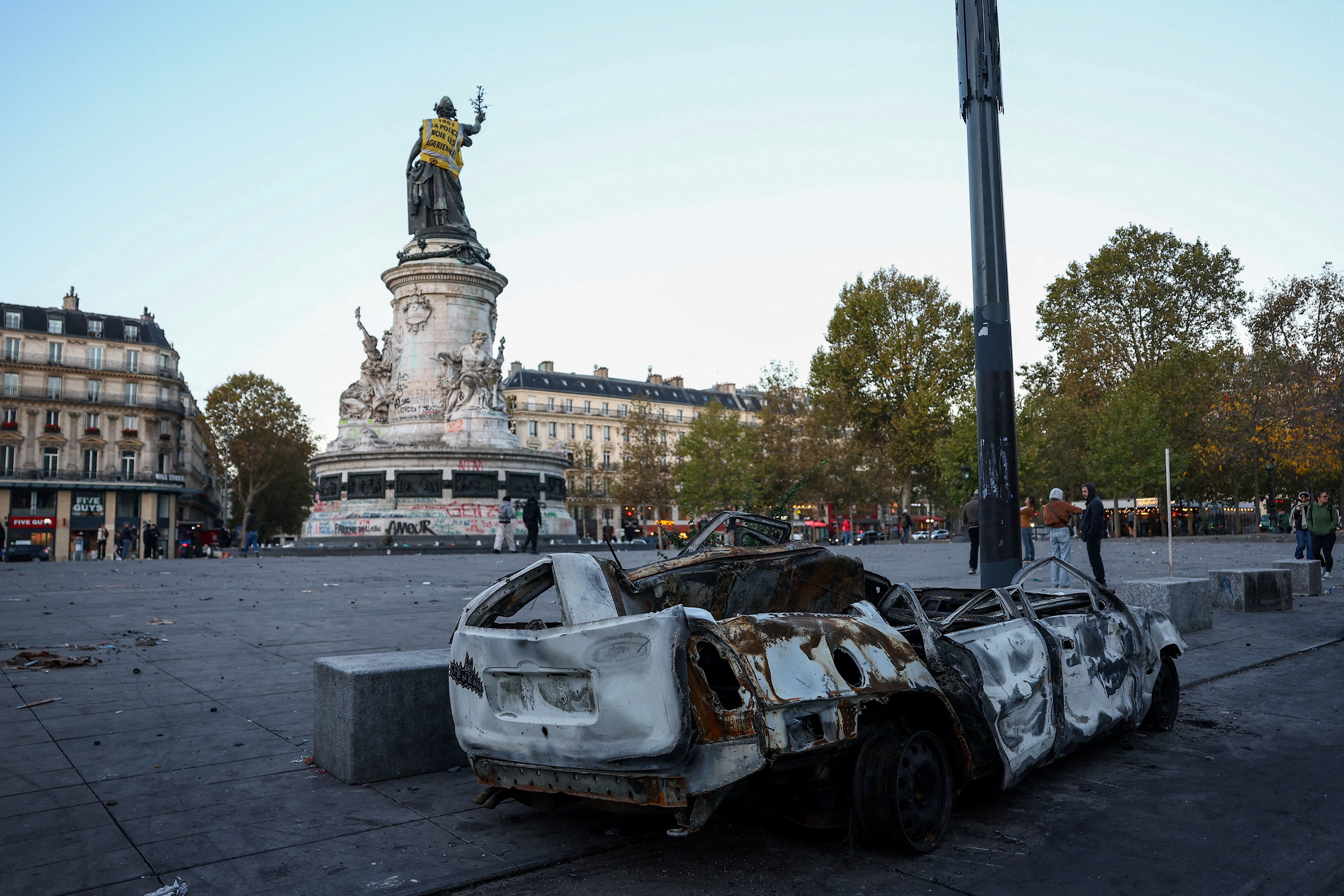 A destroyed car near the Marianne statue at the Place de la Republique, with a yellow vest put on it, the day after clashes during a national day of demonstrations against the cost of living and rising fuel prices, in Paris, France

Photo: REUTERS/Abdul Saboor TPX IMAGES OF THE DAY