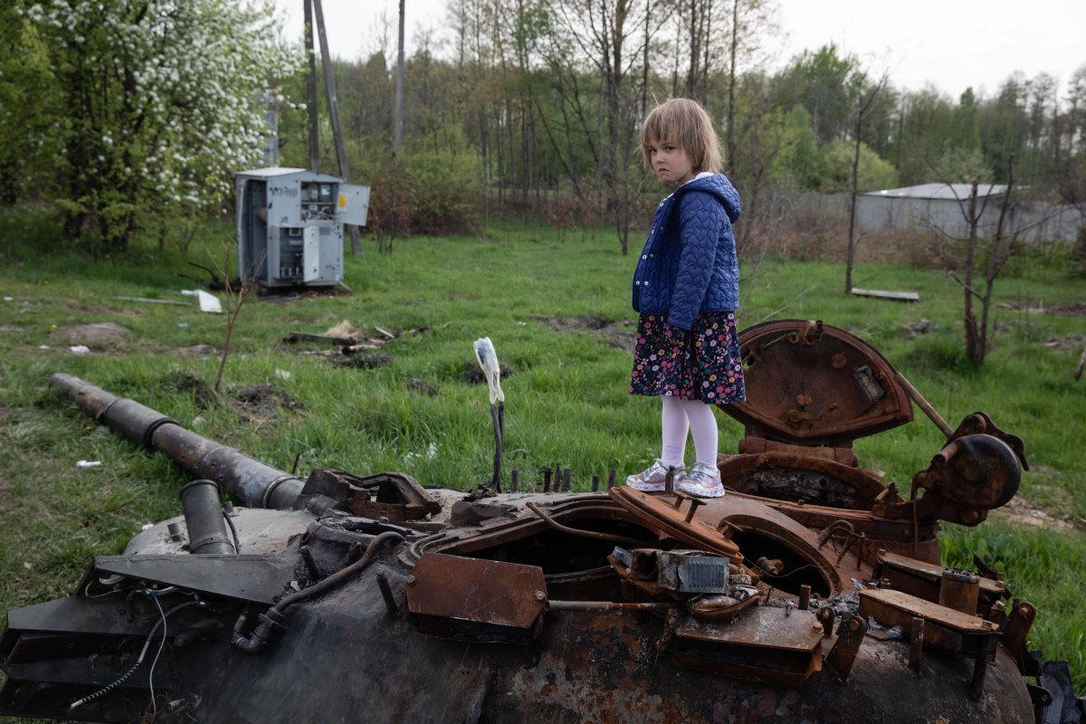 Girl standing on destroyed Russian tank. 07.05.2022 near Makariv, Kyiv region © Mikhail Palinchak, courtesy PinchukArtCentre