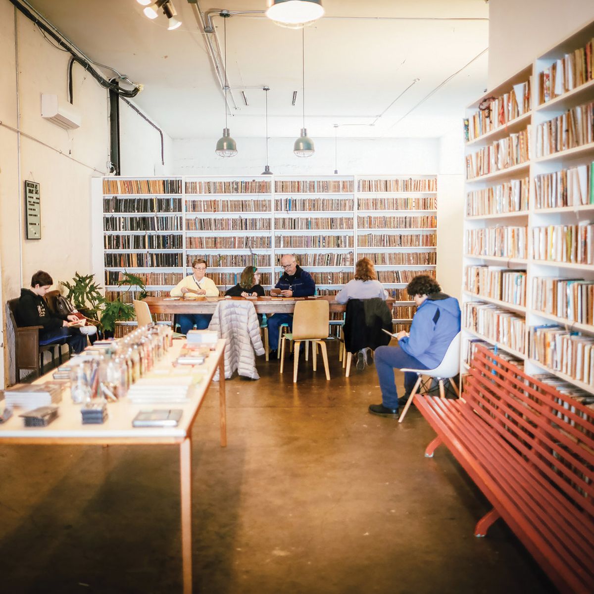 Visitors browse the collection of sketchbooks at the Brooklyn Art Library, Courtesy of Brooklyn Art Library