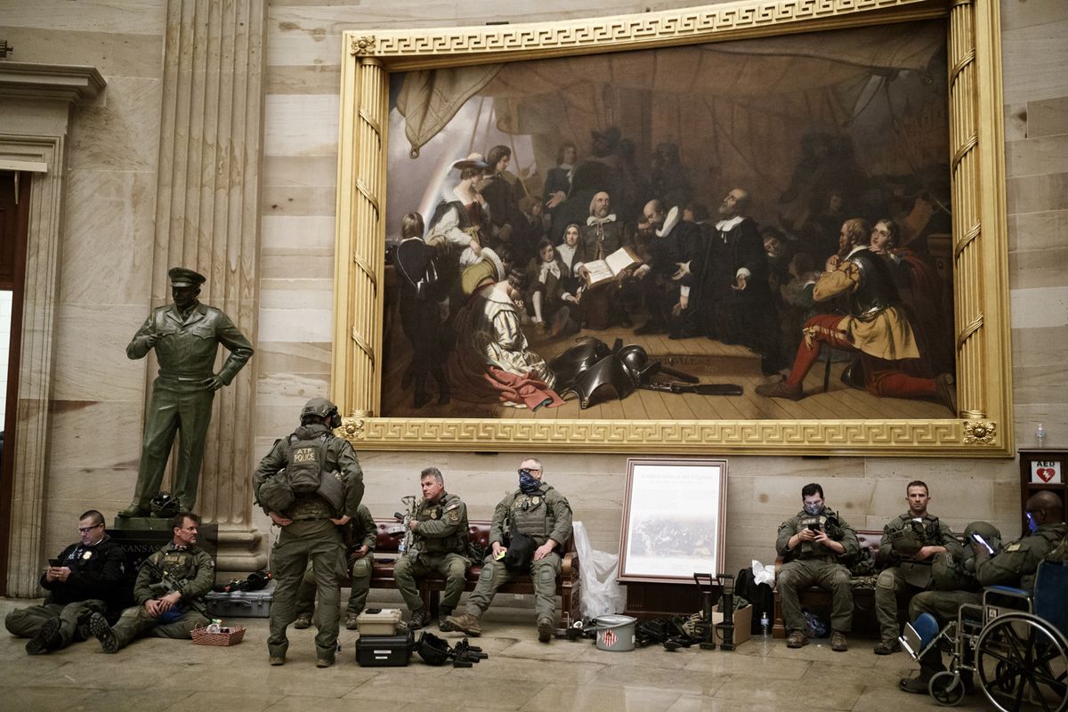 Members of law enforcement rest beneath Robert Walter Weir's painting Embarkation of the Pilgrims (around 1837) in the rotunda of the US Capitol in Washington, DC. Photo: Ting Shen/Bloomberg via Getty Images
