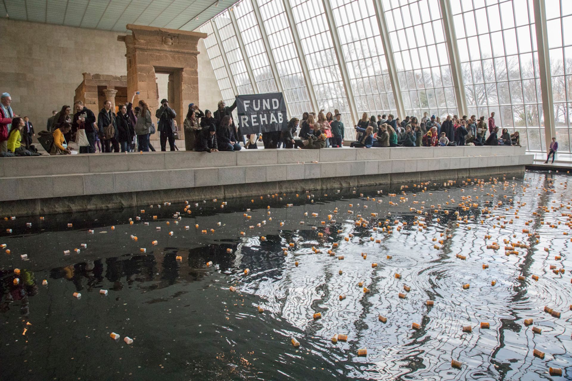 The activist group Pain (Prescription Addiction Intervention Now) stormed the Met in 2018, tossing prescription bottles of the pool surrounding the Temple of Dendur Photo: Jean-Christian Bourcart. 