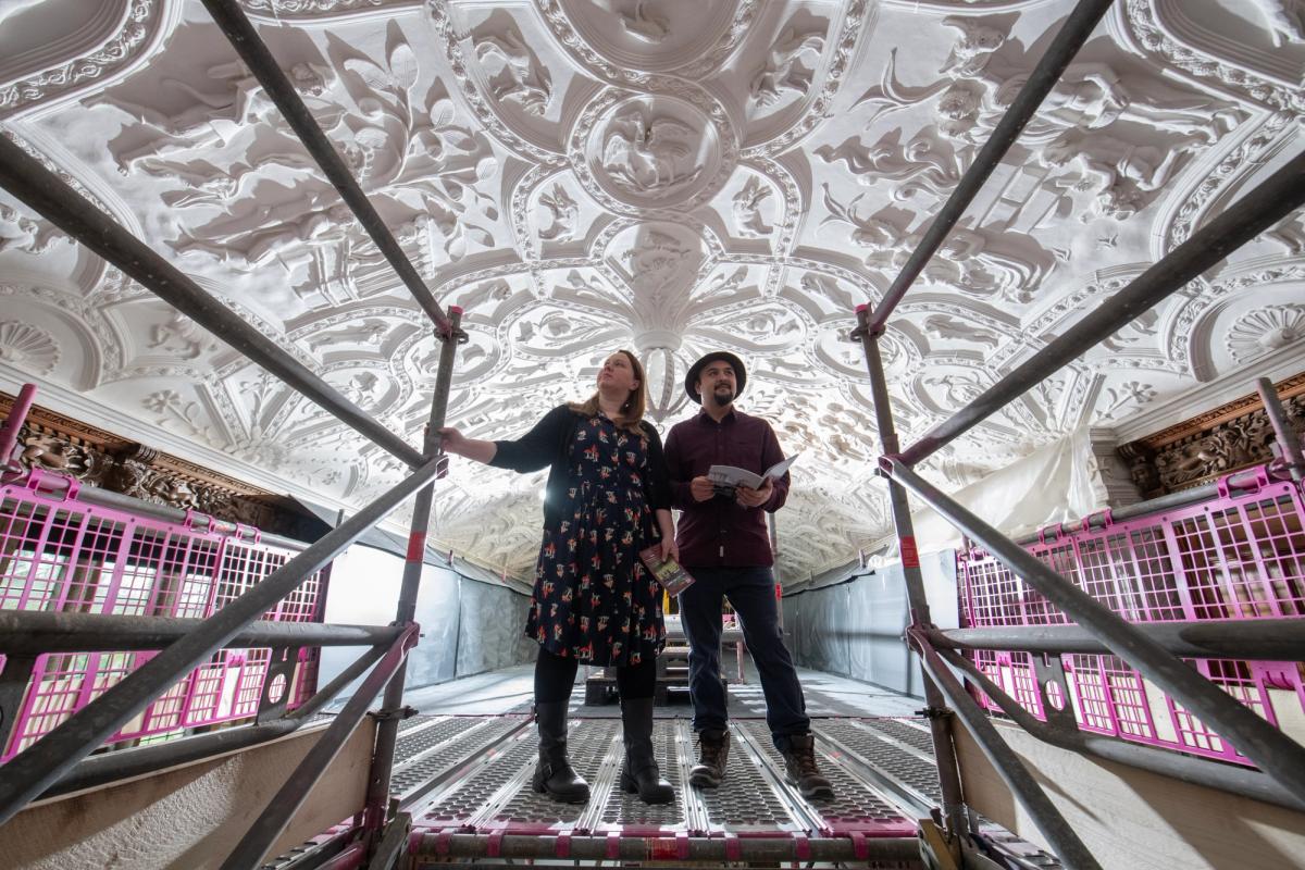 Two visitors on the scaffolding platform view the Long Gallery ceiling at National Trust Lanhydrock, Cornwall as part of the project to conserve the ceiling © National Trust Images. Steve Haywood
