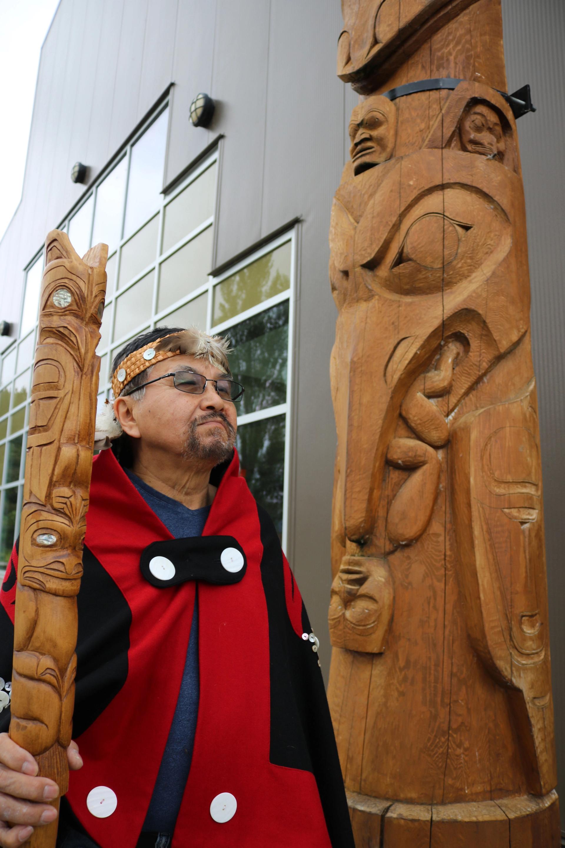 Sim’oogit Ni’isjoohl (Chief Earl Stephens) stands next to a replica of the Ni'isjoohl memorial pole in the Nisga'a Village of Laxgalts’ap, British Columbia, Canada. Courtesy of the Nisga’a Nation.