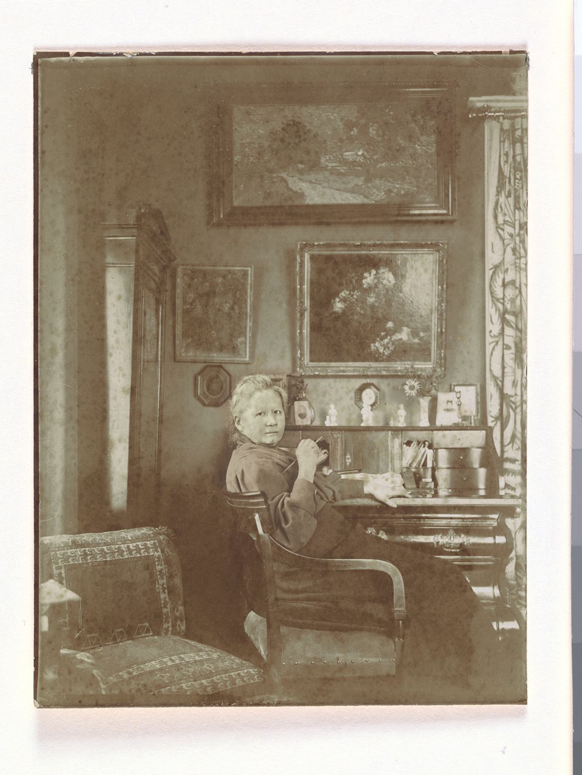 Jo van Gogh-Bonger at her desk in the living room at 77 Koninginneweg in Amsterdam (1909 or later). On the wall behind the desk are Fantin-Latour’s Flowers and Vincent van Gogh’s Vase of Honesty (1884), with Landscape at Twilight (1890) at the top Credit: Unknown photographer. Van Gogh Museum; Amsterdam (Vincent van Gogh Foundation)