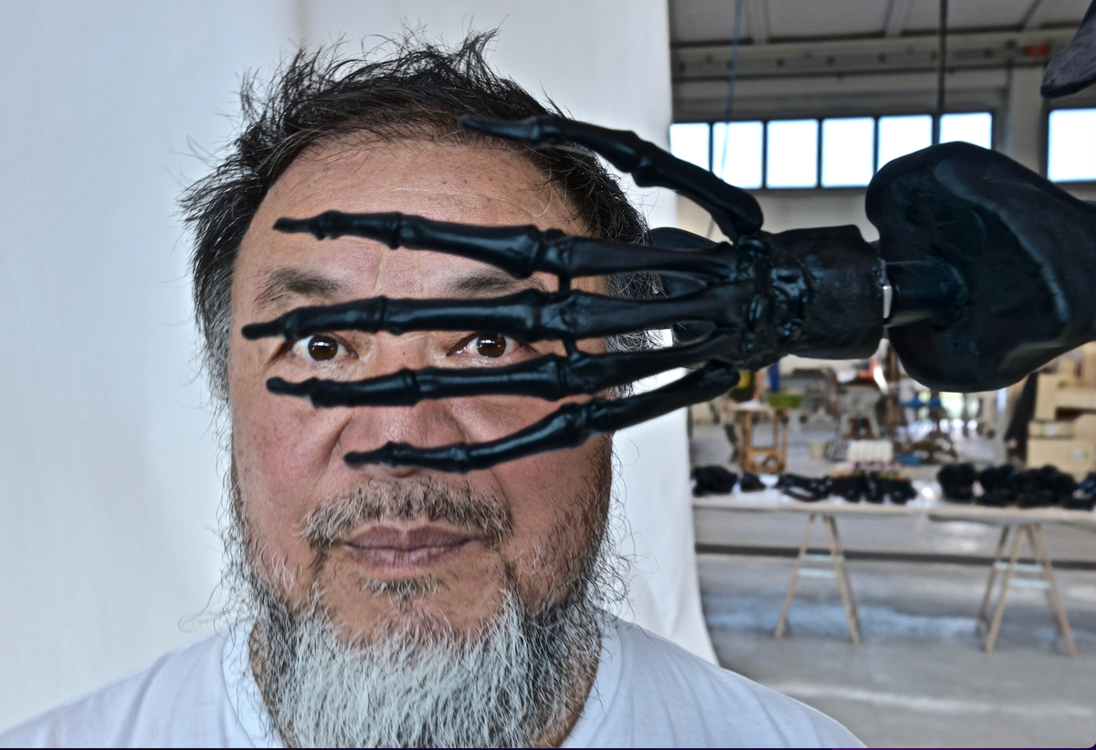 Portrait of Ai Weiwei with detail from his sculpture The Human Comedy. Photography: Edward Smith 