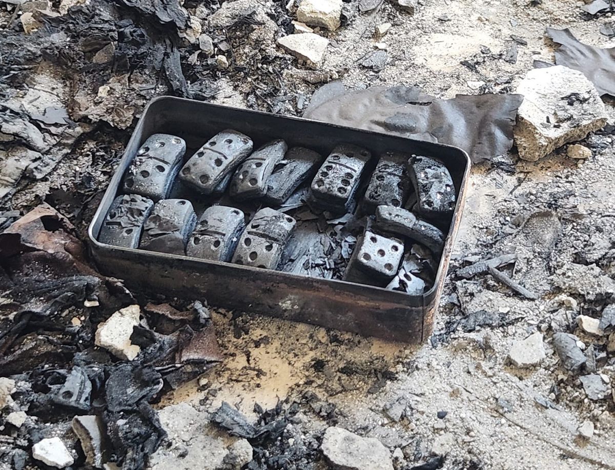 A box of charred dominoes at one of the sites attacked by Hamas on 7 October. So far, archaeologists from the Israeli Antiquities Authority have recovered remains of 12 people Israel Antiquities Authority