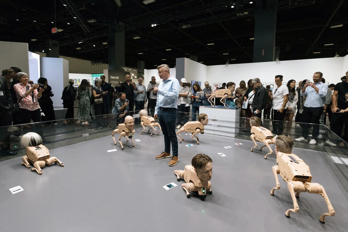 The artist Beeple (centre) discusses his robotic dog sculptures, which have been the talk of Art Basel Miami Beach
Liliana Mora