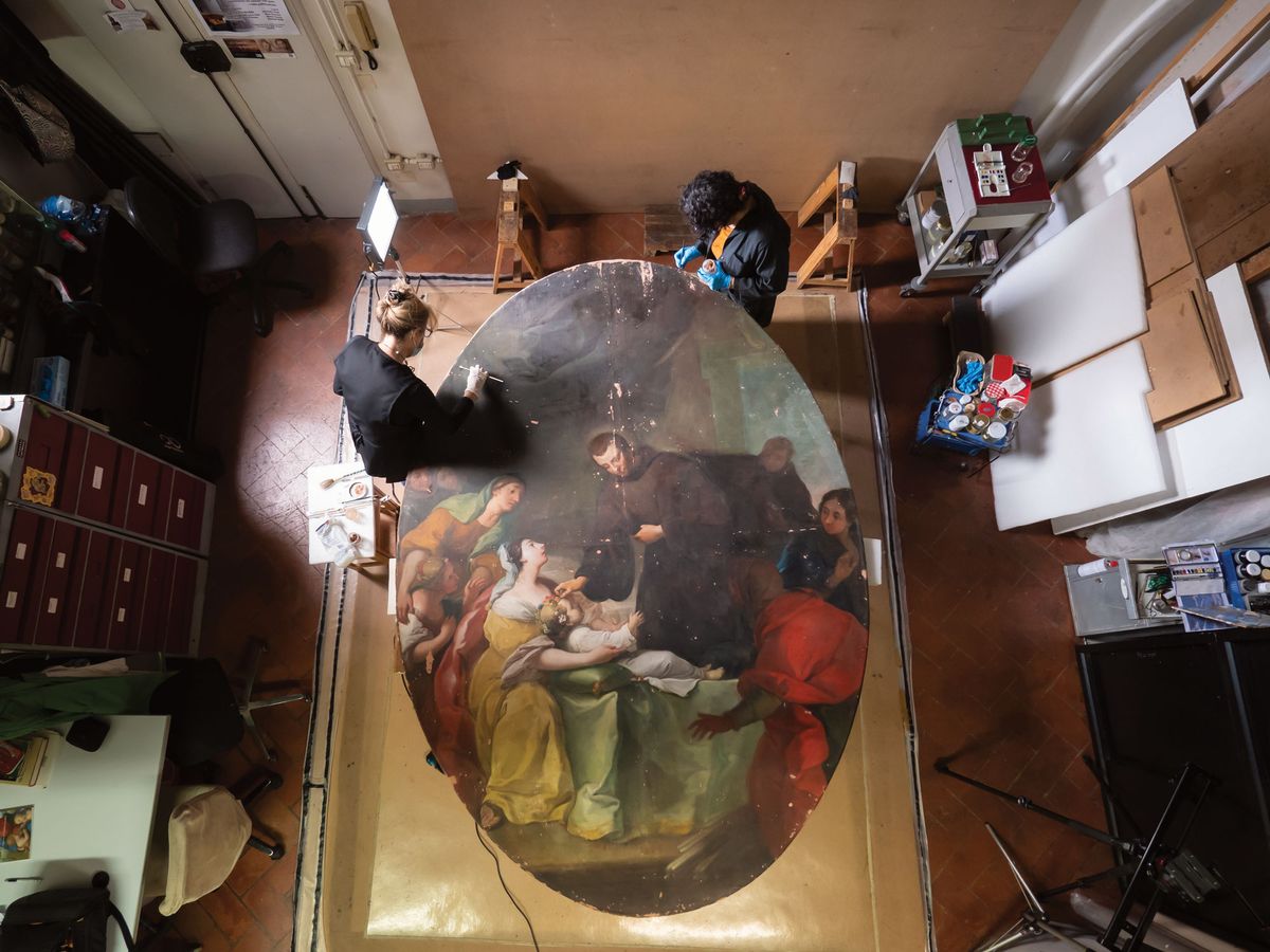 Conservators Elizabeth Wicks and Marina Vincenti are working on the restoration of Violante Ferroni’s Saint John of God Heals Plague Victims (1756), which will be reinstalled this May at San Giovanni di Dio Hospital in Florence Photo: Francesco Cacchiani