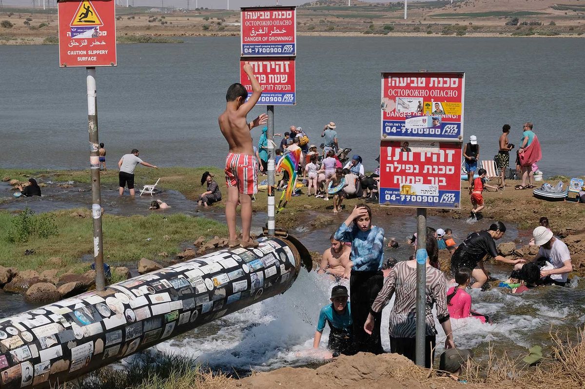 In Levac’s Bathers in Bental Reservoir in Ramat Hagolan, August 2026, people studiously ignore warning notices Courtesy the artist