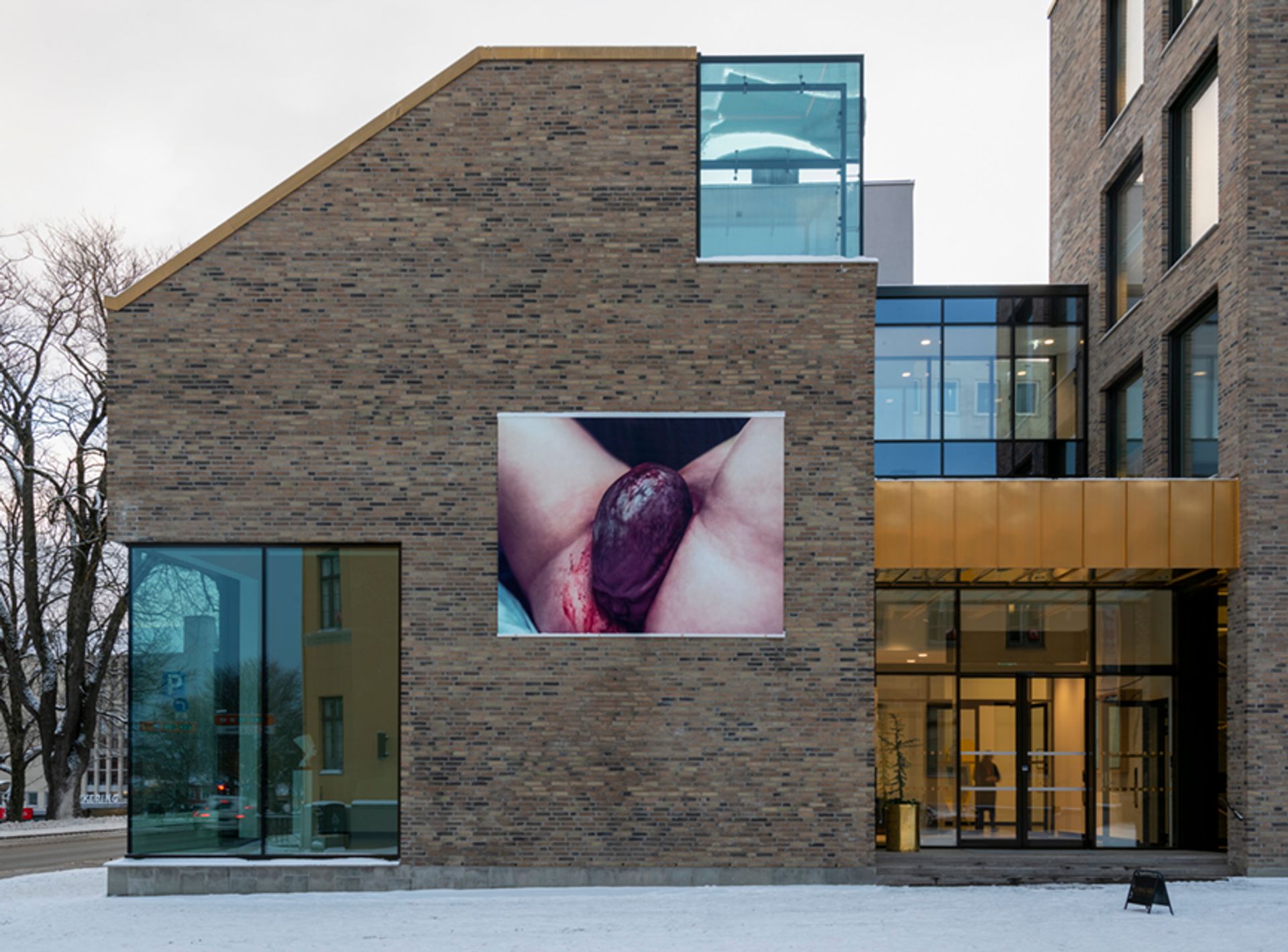 Heji Shin's photo of a crowning baby is featured on the side of the newly opened KUK Trondheim. Courtesy of KUK Trondheim