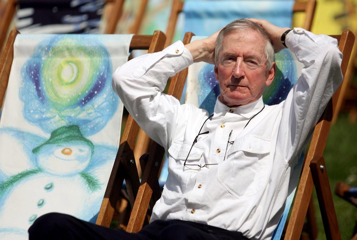 The author and illustrator Raymond Briggs posing beside a deckchair decorated with a character from his 1978 book The Snowman, in Hyde Park, London, in 2008. Photo: PA Images / Alamy Stock Photo