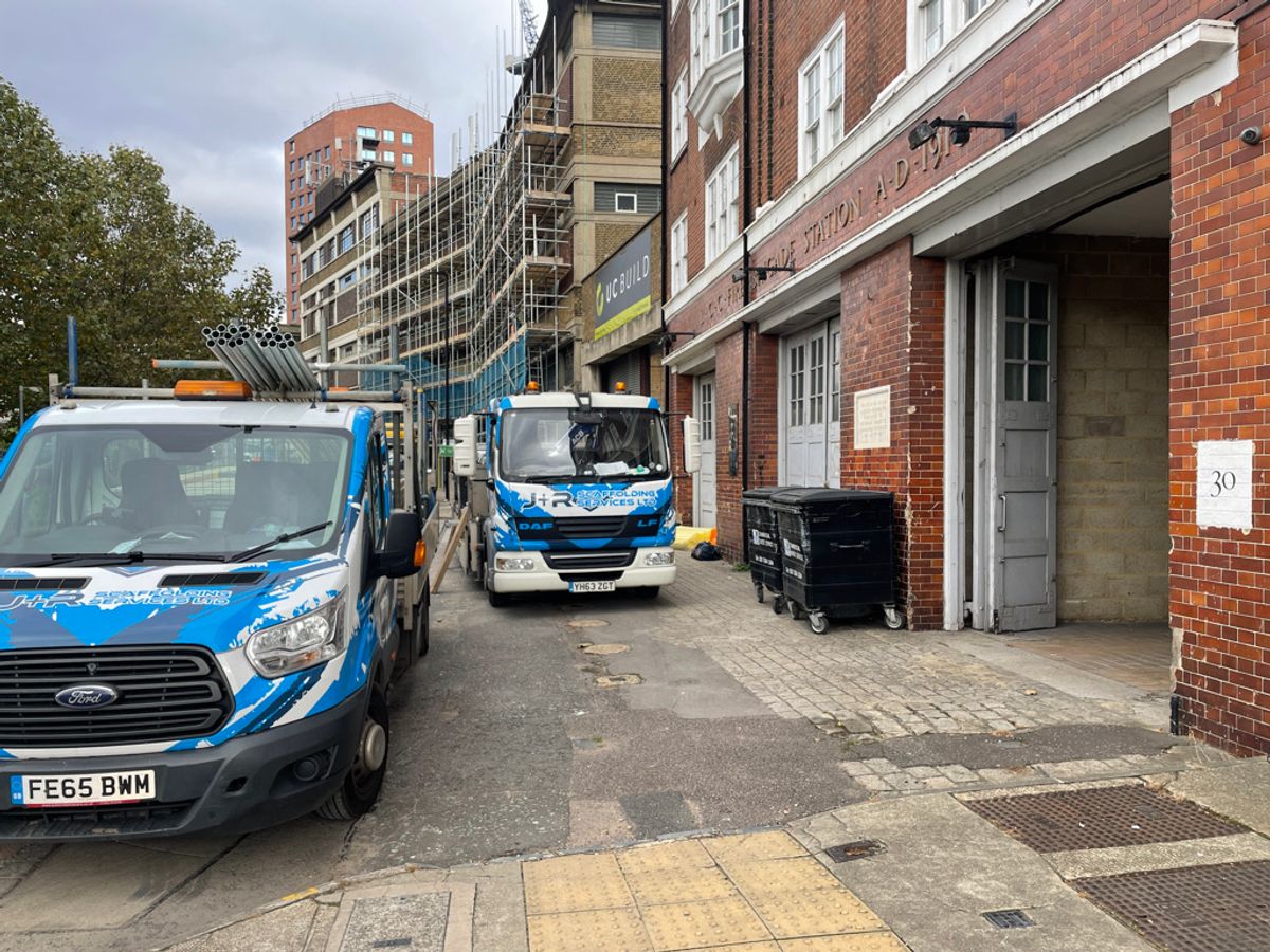 Builders' vans outside the Fire Station building, which houses the live/work spaces
