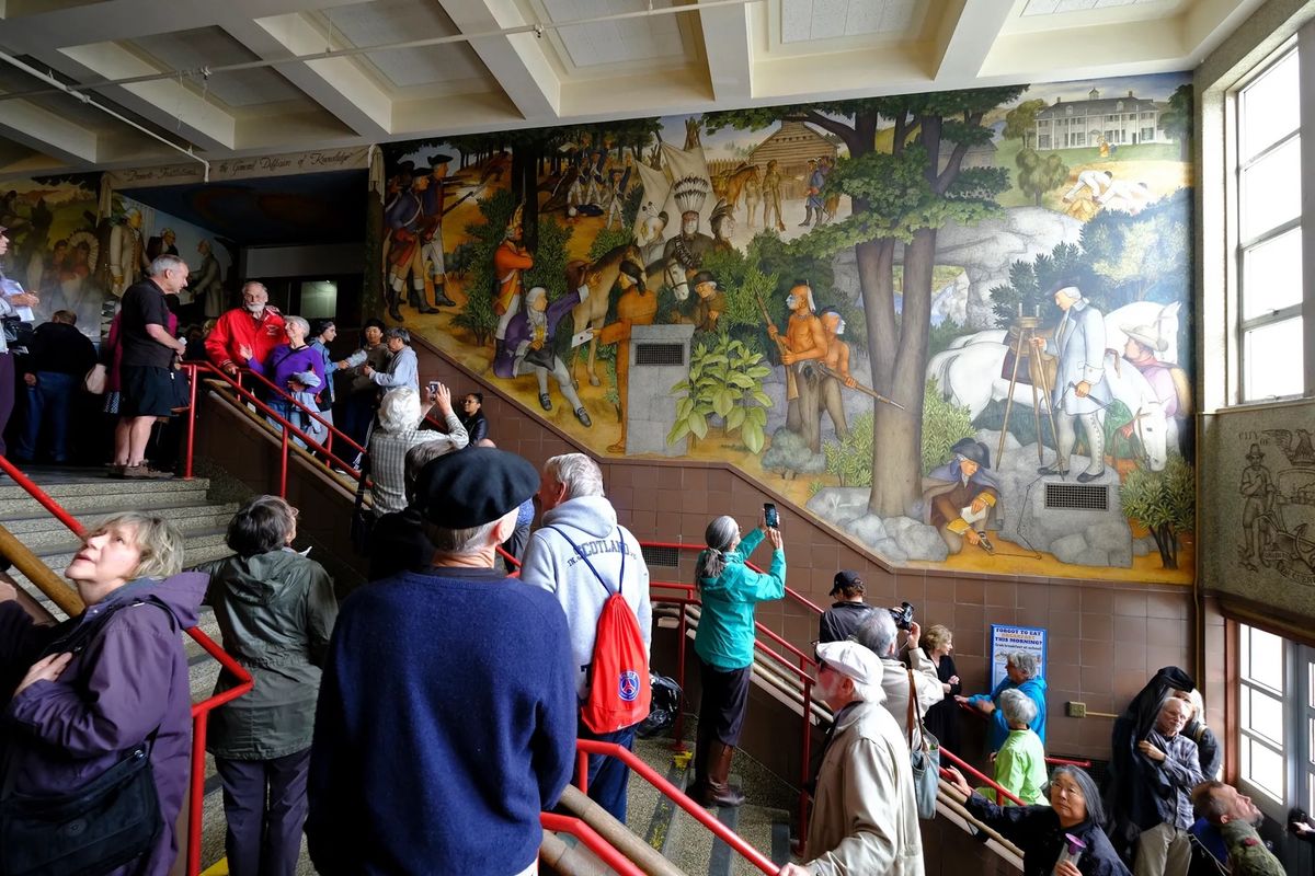 Visitors viewing a mural at George Washington High School in San Francisco at an open house  in 2019 AP Photo/Eric Risberg