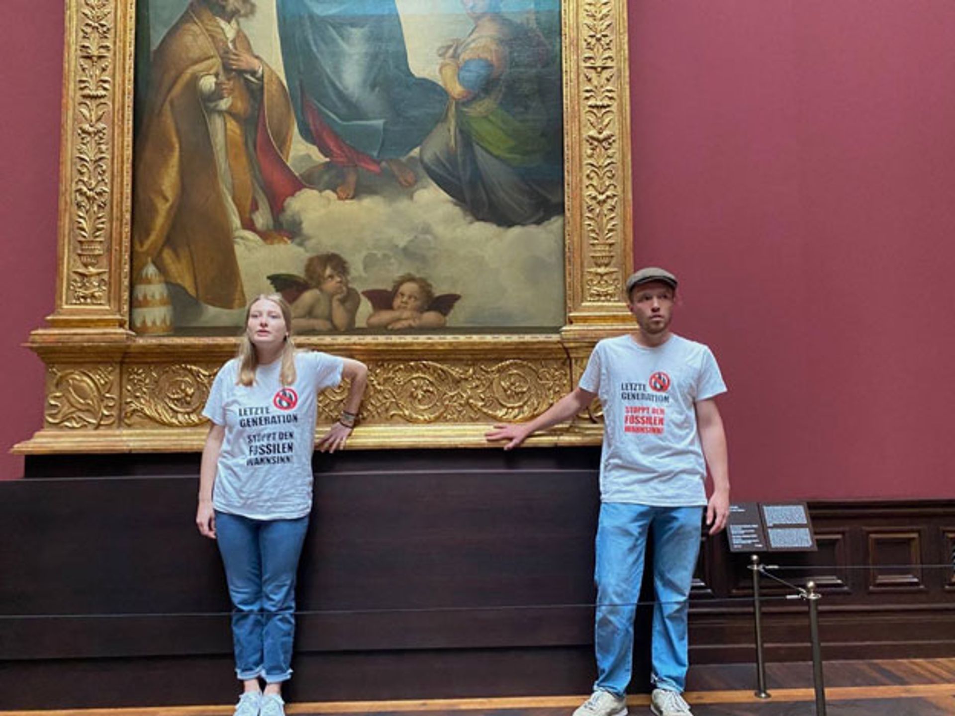 Protesters from Letzte Generation glue themselves to the frame of Raphael's Sistine Madonna (1512-13) in the Gemäldegalerie Alte Meister in Dresden