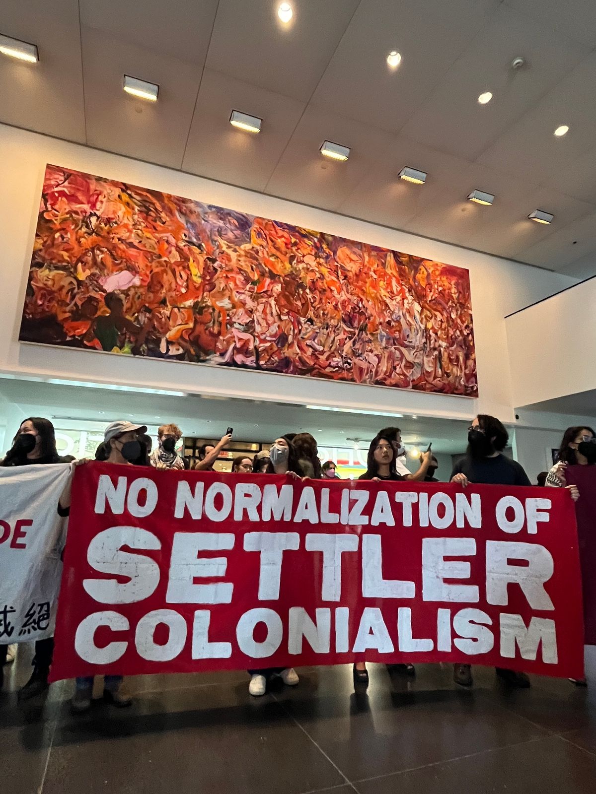 Protesters carry a banner beneath a Cecily Brown painting in the lobby of the Brooklyn Museum on 31 May Photo by Gwendolen Cates