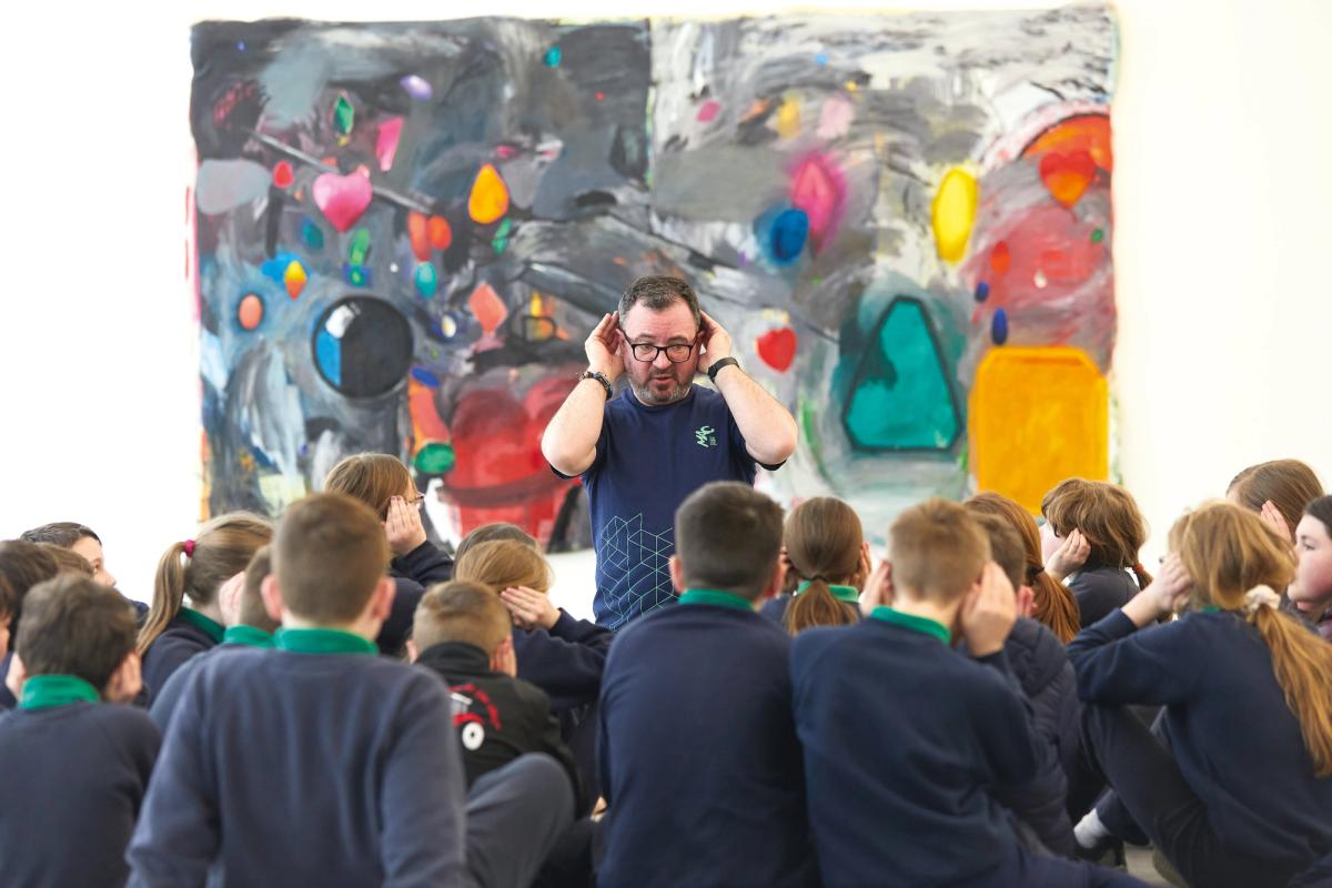 Looking at an work by Yasmine Robinson, schoolchildren take part in Gallery in a Box with the artist Jason Parkes © Janie Airey, Art Fund 2023