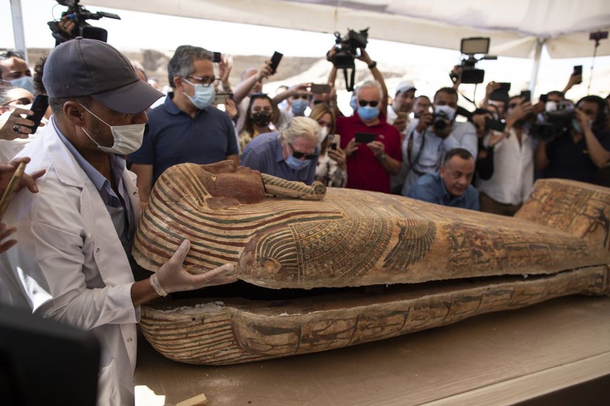 An archaeology worker opens a sarcophagus at the Saqqara archaeological site, in the presence of journalists and officials AP Photo/Mahmoud Khaled