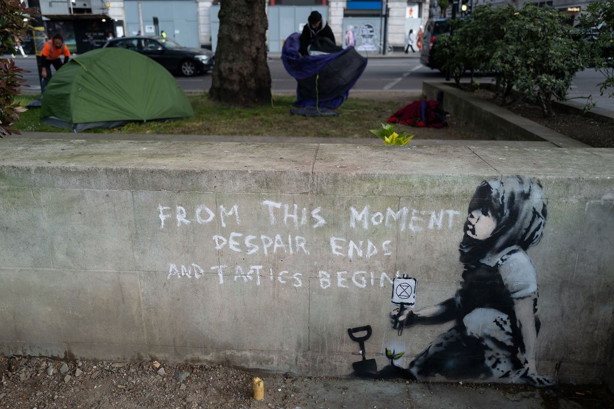 A new piece of street art believed to be by Banksy appeared on 26 April in London.  The works shows a child holding a small Extinction Rebellion sign crouching by a newly-planted seedling with the words "From This Moment Despair Ends And Tactics Begin" Photo: Leon Neal/Getty Images