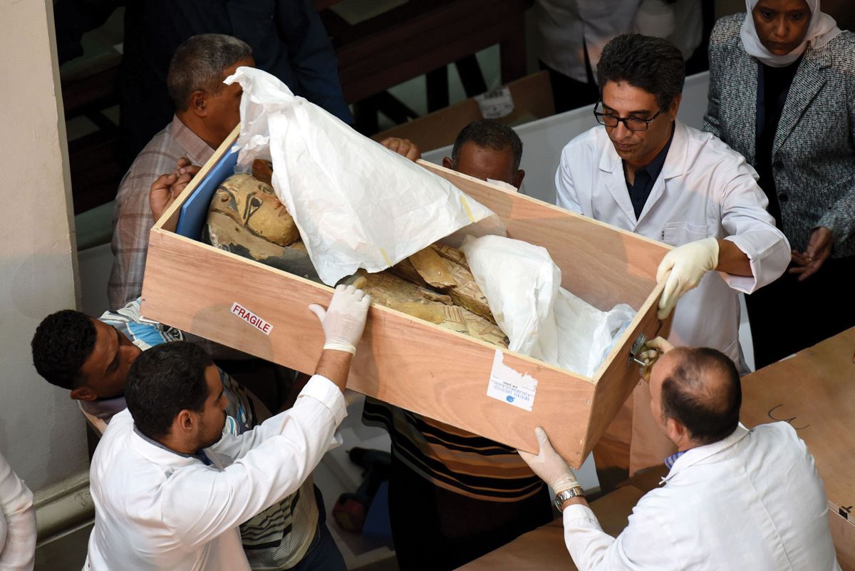 Egyptian museum staff with a sarcophagus repatriated by the Israeli government in 2016 after discovering it had been looted MOHAMED EL-SHAHED/AFP/Getty Images