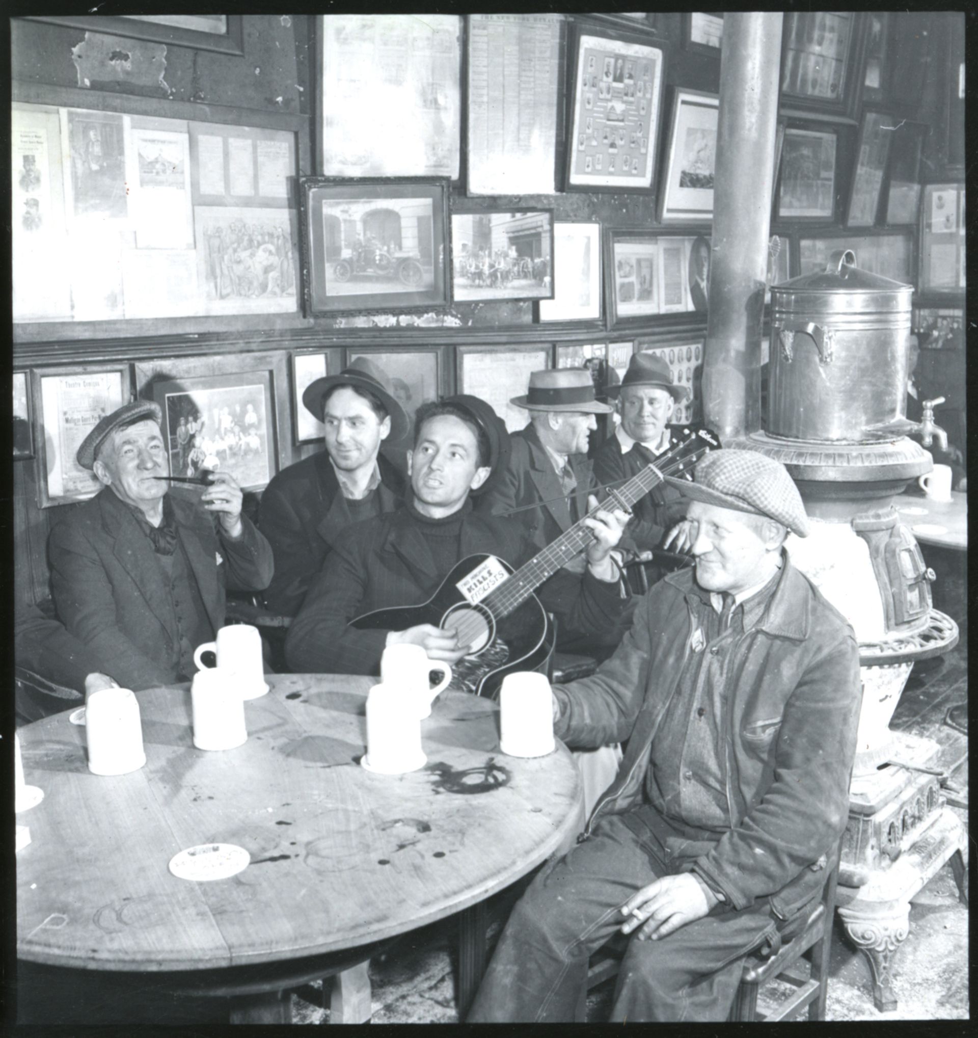 Woody Guthrie (centre) at McSorley's Pub in Manhattan Photo by Eric Schaal, Courtesy of the Woody Guthrie Archive