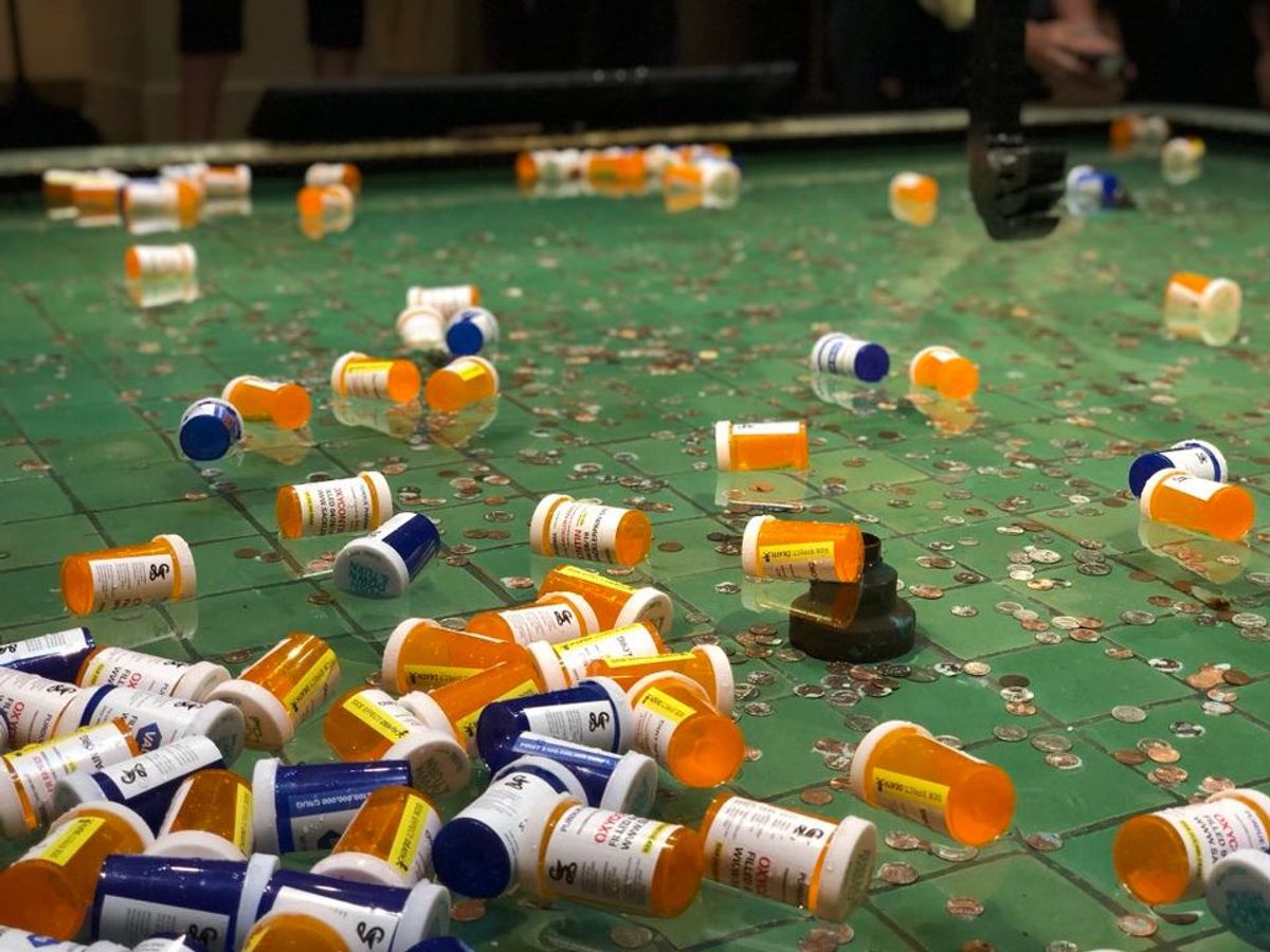 Pill bottles were thrown by protesters into a pool below a sculpture by Xu Bing at the Sackler Gallery in Washington, DC on 26 April 2018 © Via Twitter @gohedgeclippers