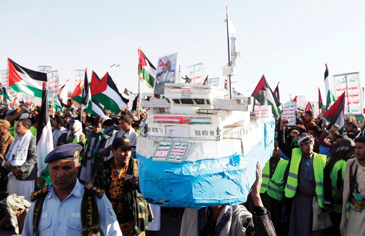 A Yemeni man carries a model of the Houthi-hijacked Galaxy Leader cargo ship Photo: Mohammed Hamoud/Getty Images