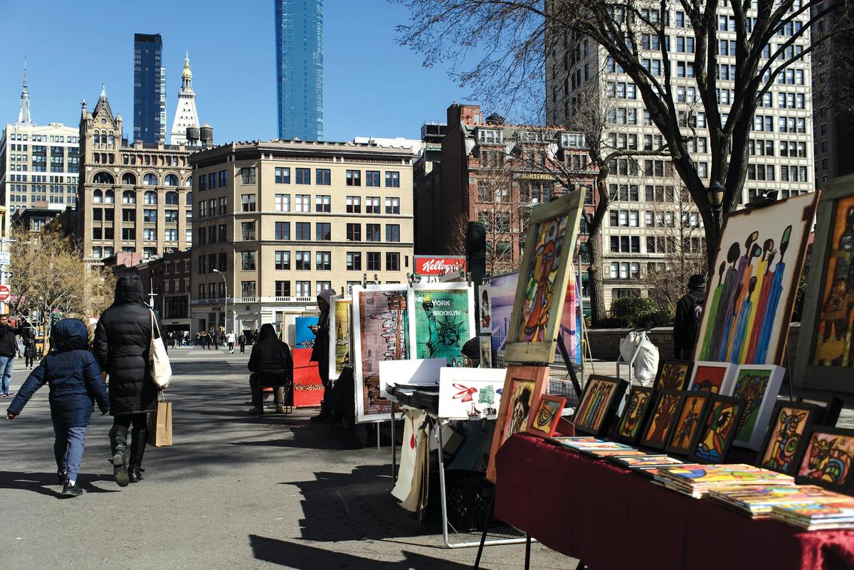 A mother and child walk by stalls selling art in Union Square, New York Photo: PJ Norman