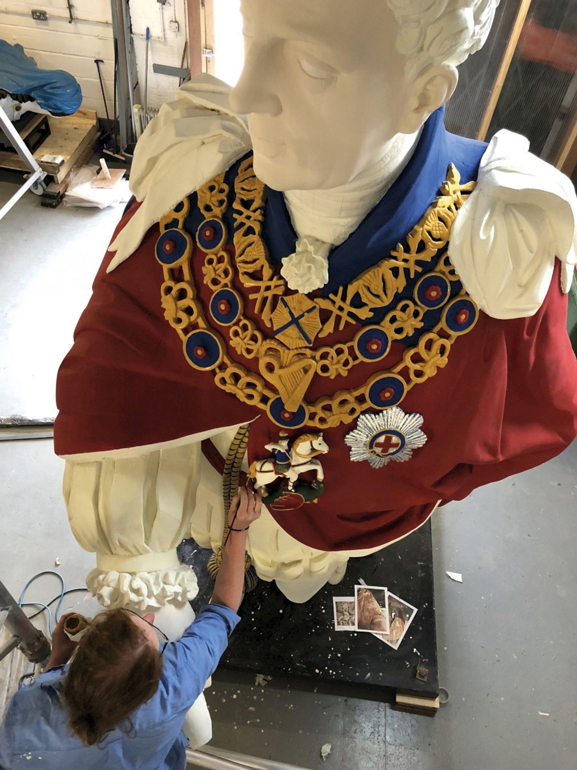 A conservator works on “King Billy”, the figurehead of the 1830s HMS Royal William Courtesy of Orbis Conservation