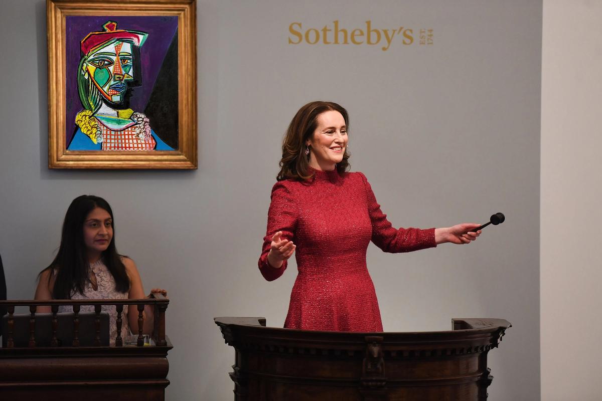 Sotheby's auctioneer Helena Newman in front of Picasso's 1937 portrait, Femme au béret et à la robe quadrillée (Marie-Thérèse Walter) Sotheby's