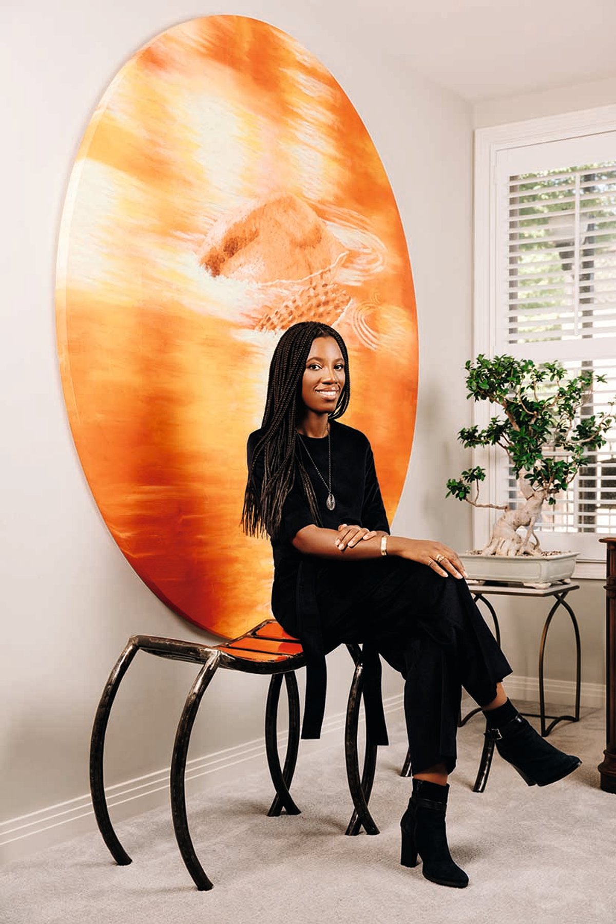 Collector and designer Catherine Sarr at home in front of Joël Degbo’s 2017 painting Les Maîtres de l’eau
Photo: Dave Kasnic