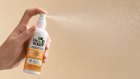 Close-up of a Dr. Whiff spray mist catching the light against a soft neutral background