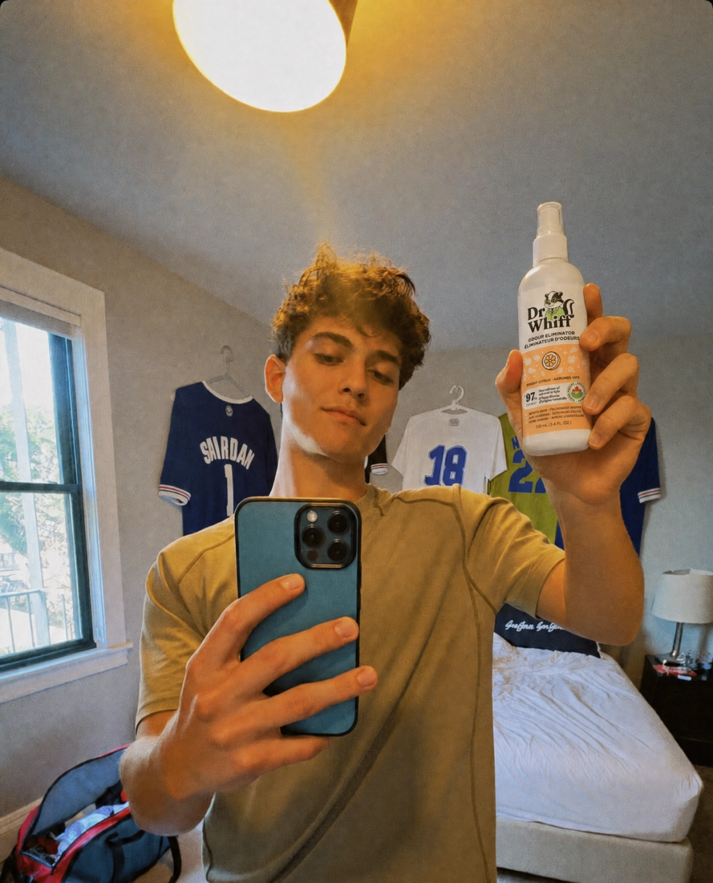 Spraying Dr. Whiff into a gym bag with workout gear