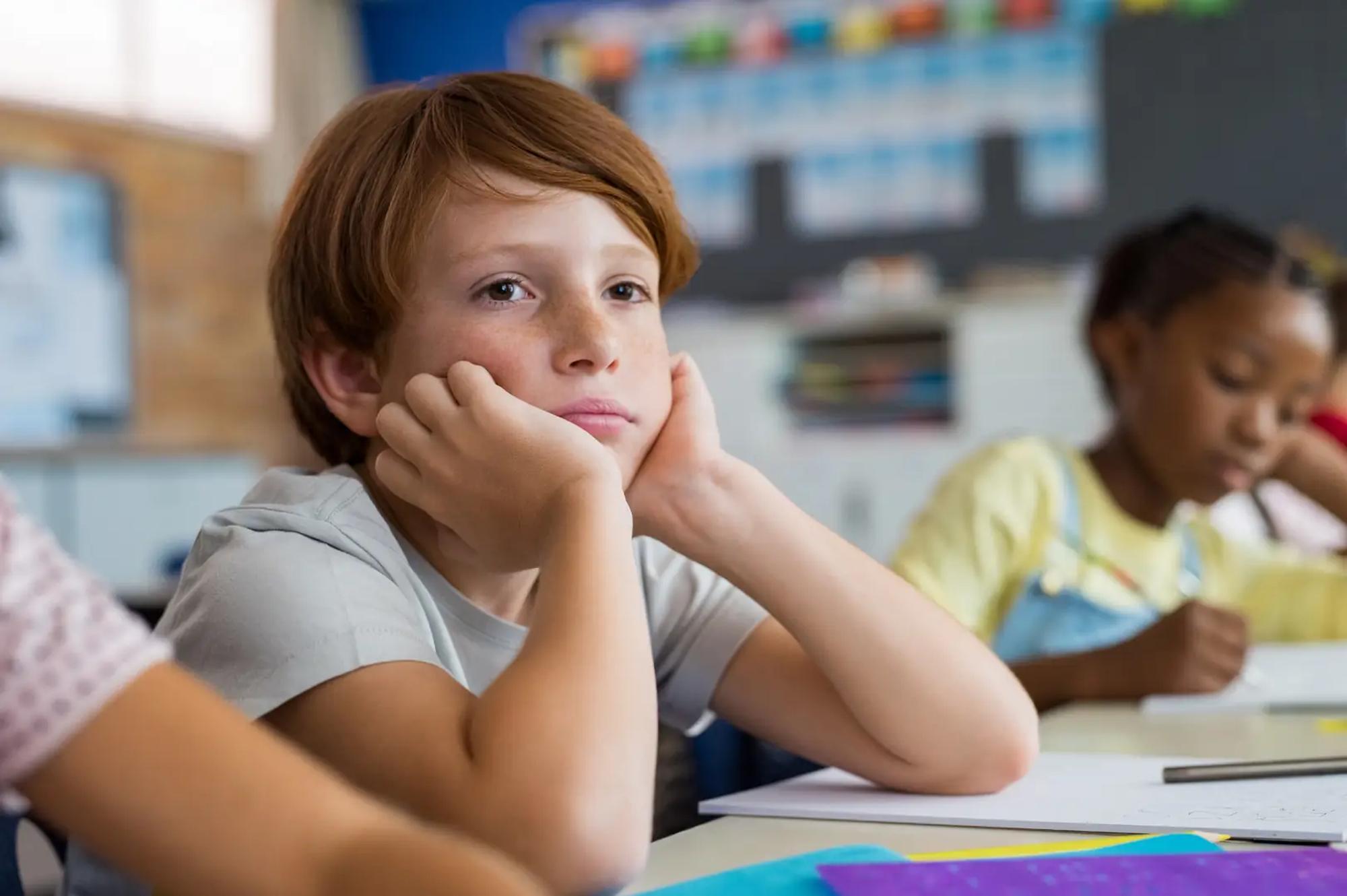A child's school report on a kitchen table beside a mug.