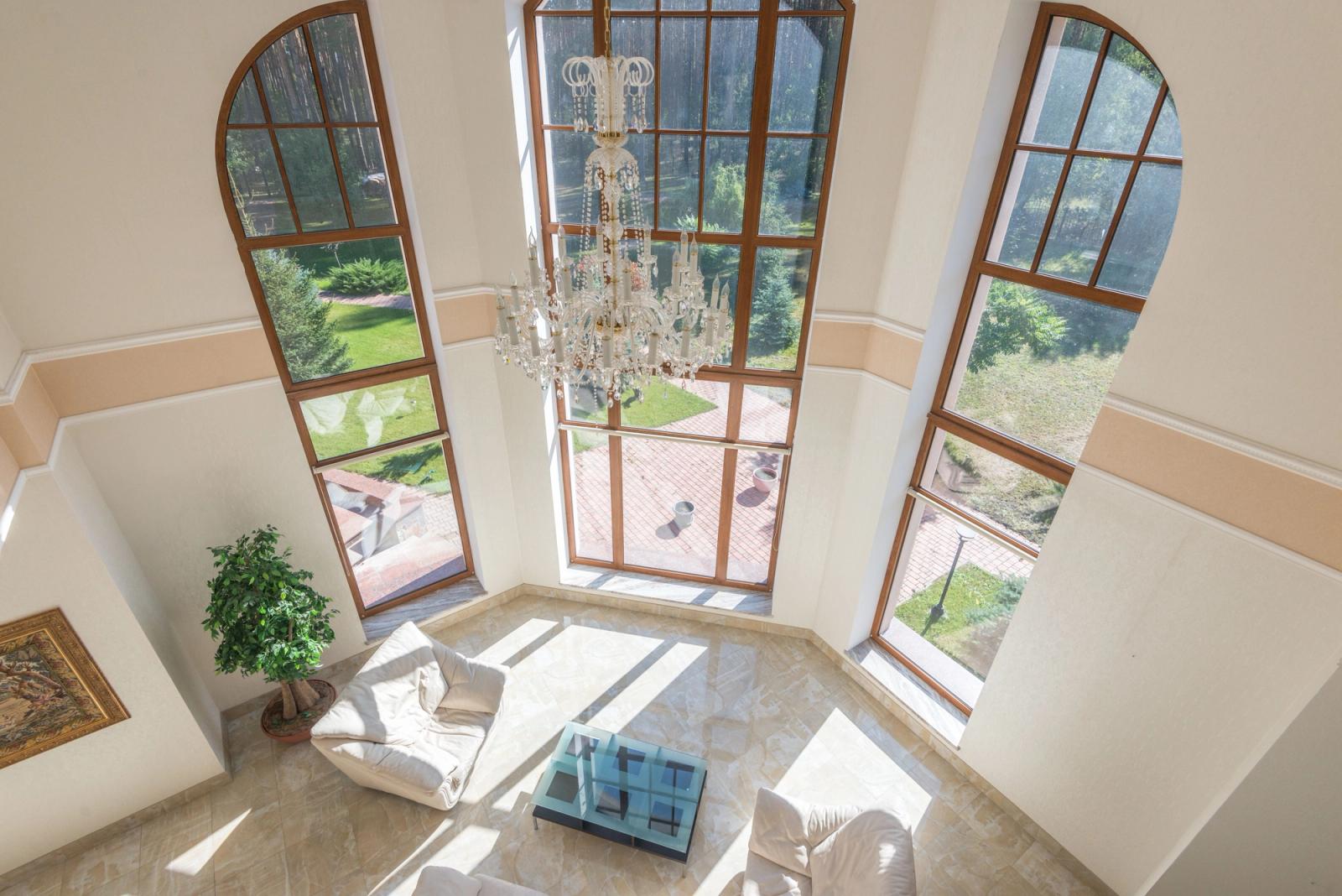 A turreted, chateau-style stucco villa with landscaped grounds.