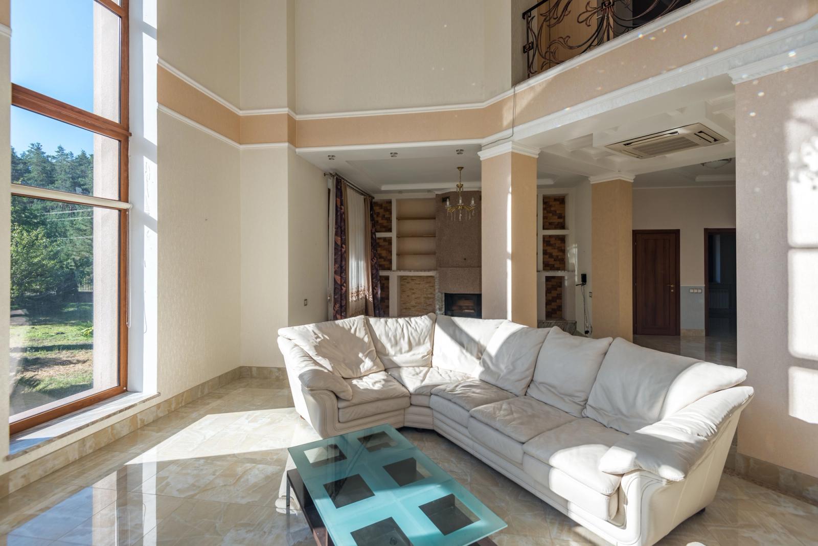 A turreted, chateau-style stucco villa with landscaped grounds.