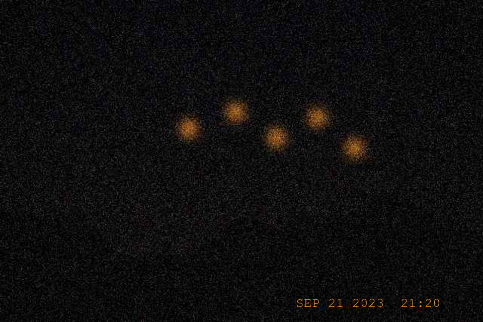 Five amber orbs over the ridge