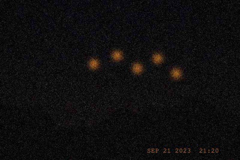 Five amber orbs over the ridge