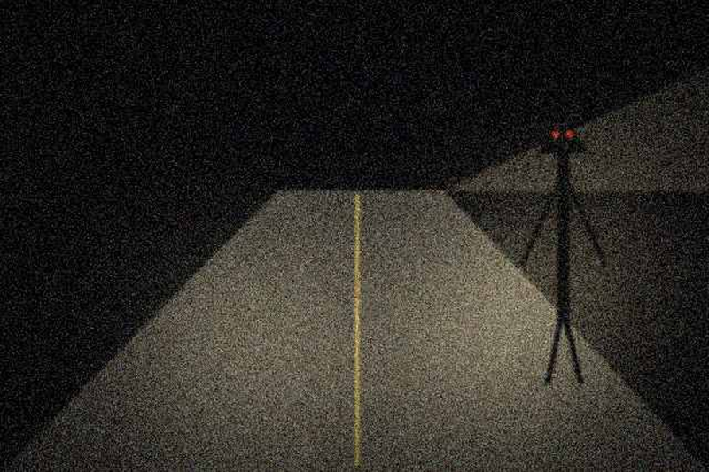 Thin figure at the edge of the headlight beam