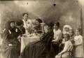 Group portrait of women and children seated around a table with tea service, photographed by Vasil Roinashvili.
